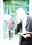 Businessman using cell phone, blurred