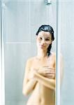 Woman taking shower, covering breasts