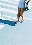 Woman crossing street, low section