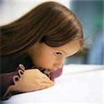 Girl leaning on table, side view