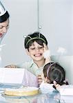 Girl and boy with mother having birthday party