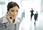 Businesswoman using cell phone in office lobby