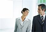 Businesswoman smiling at male colleague