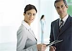 Businessman and businesswoman standing with file