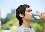 Jeune homme à l'eau potable de bouteille