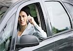 Businesswoman using cell phone in car