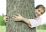 Girl hugging tree and smiling