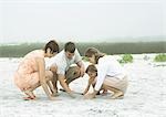 Family playing in sand together