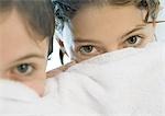 Two girls looking over edge of towel