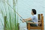 Young man fishing on dock
