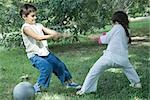 Boy and girl playing tug-of-war