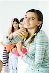 Preteen girl putting apples in shirt while older friends watch in background