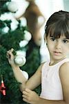 Girl holding branch of Christmas tree