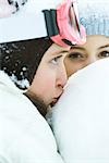 Teenage girl kissing snowball, close-up, ami en arrière-plan