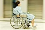 Femme à l'aide de fauteuil roulant, pleine longueur, flou de mouvement