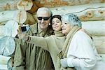 Teenage girl photographing self with grandparents