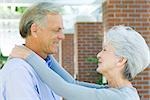 Mature couple smiling at each other, face to face, side view