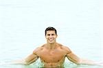 Homme en piscine, souriant à la caméra, portrait