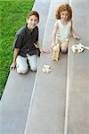 Brother and sister on stairs, playing with blocks together, high angle view