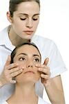 Woman receiving facial massage, looking up and away