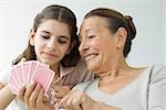 Senior woman and granddaughter playing cards