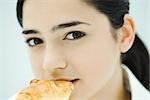 Young woman eating croissant, close-up