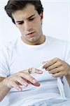 Man wrapping gauze around injured finger