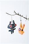 Dolls hanging from branch