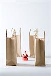 Santa Claus figurine surrounded by paper shopping bags