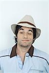 Young man wearing hat, winking at camera, portrait