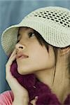 Teen girl wearing sun hat and fur scarf, holding fur to face, close-up, portrait