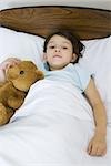 Kinder liegen im Bett mit Teddybär
