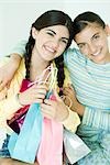 Two young female friends, one holding gift bags