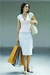 Woman holding shopping bags, full length portrait