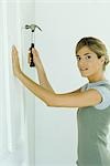 Woman hammering nail into door