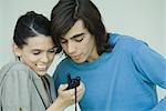 Teen couple looking at cell phone together