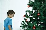 Boy standing by Christmas tree