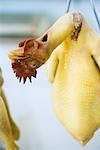 Raw skinned chicken hanging from hook