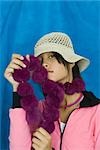 Teenage girl wearing hat, holding boa against face, portrait