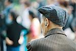 Homme Senior écouter écouteurs vue arrière de la tête et des épaules