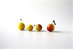 Four mirabelle plums in a row