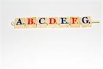 Wooden alphabet blocks lined up, close-up