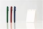 Colorful pens upright on table, notebook