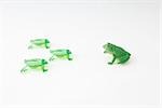 Plastic frog facing group of frog shaped game pieces
