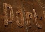 Port typography on rusted surface.