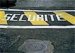 Safety stenciled text in French on street.