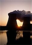 Nuclear reactors reflected in water at sunrise