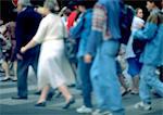 Crowd walking on crosswalk, side view, defocused