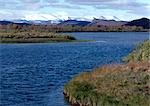 Finland, lake with snow covered mountains in background