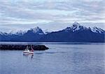 Norway, fishing boat close to jetty, snow-capped mountains in background